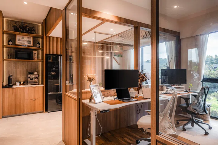A half-height wall with glass defines the work zone while preserving light and connection—proof that in compact homes, daily habits should shape the layout and not the other way around.