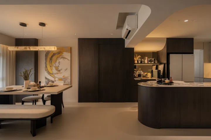 The open-plan layout is oriented around the TV, allowing viewing from the sofa, dining table, and kitchen island.