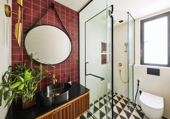 The maroon wall
tiles and black
and white floor
tiles give the
guest bathroom
a dynamic look.