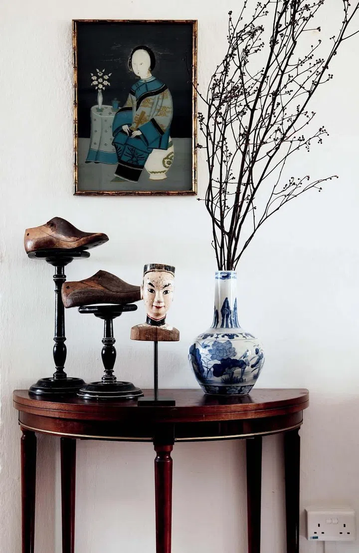 The original bare white space of the apartment was a perfect canvas for the homeowner’s decor pieces. A framed art pieces hangs above Parisian antique market finds such as the wooden shoe moulds. Choosing pieces with history, most of the items have a 18th century baroque style and an industrial vintage look.