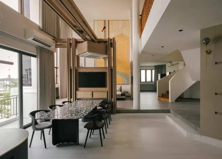 A shift in floor level subtly separates dining and living, creating distinction without interrupting flow.