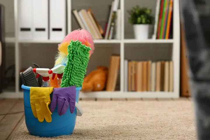 A bucket with cleaning equipment stands