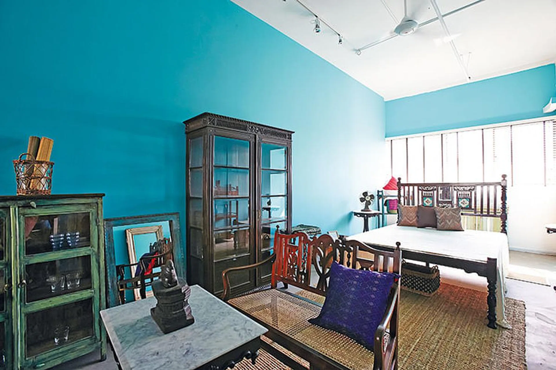 The turquoise walls brighten the showroom and accentuate the antiques on display at Artful House furniture in Tan Boon Liat Building.