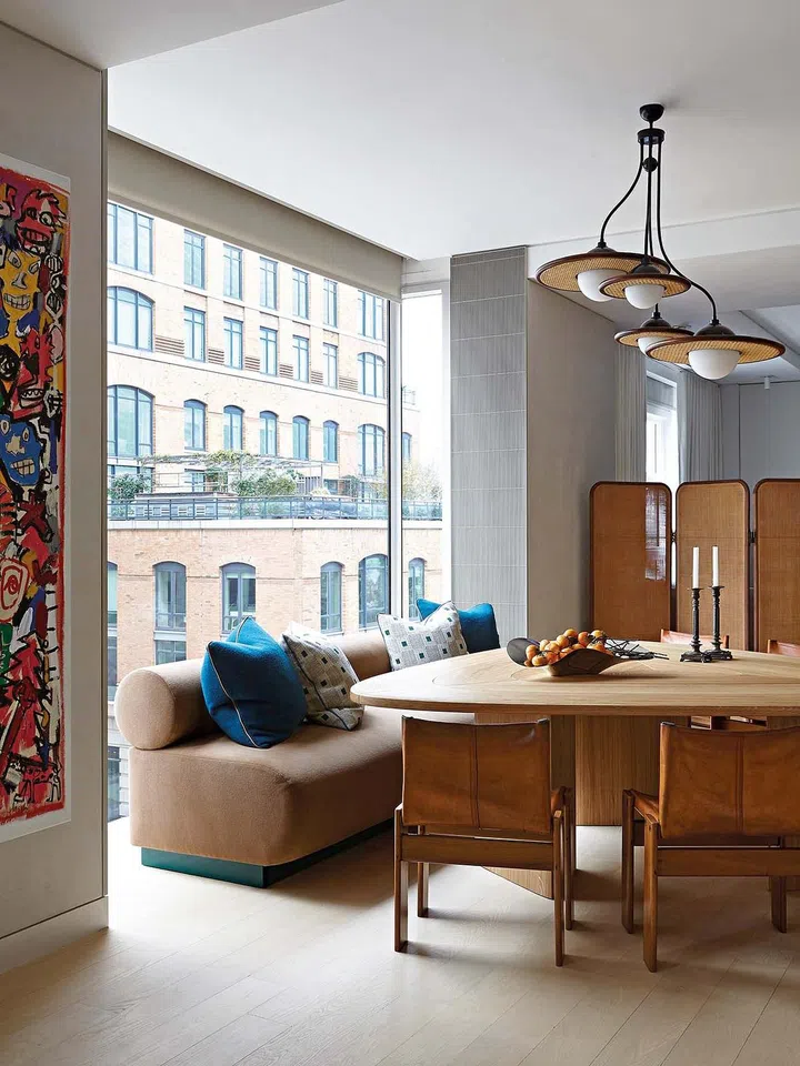 Pierre
Yovanovitch
table; custom
banquette
by McKay in
a Holly Hunt
fabric; pillows
on banquette
by Tibor and
Holland & Sherry
fabrics; vintage
chairs by Tobia
and Afra Scarpa;
cane screen/
room-divider

by Quincoces-
Drago from

Six Gallery;
candelabra by
Arthur Umanoff
from Maison
Gerard; pendant
light by Merve
Kahraman.