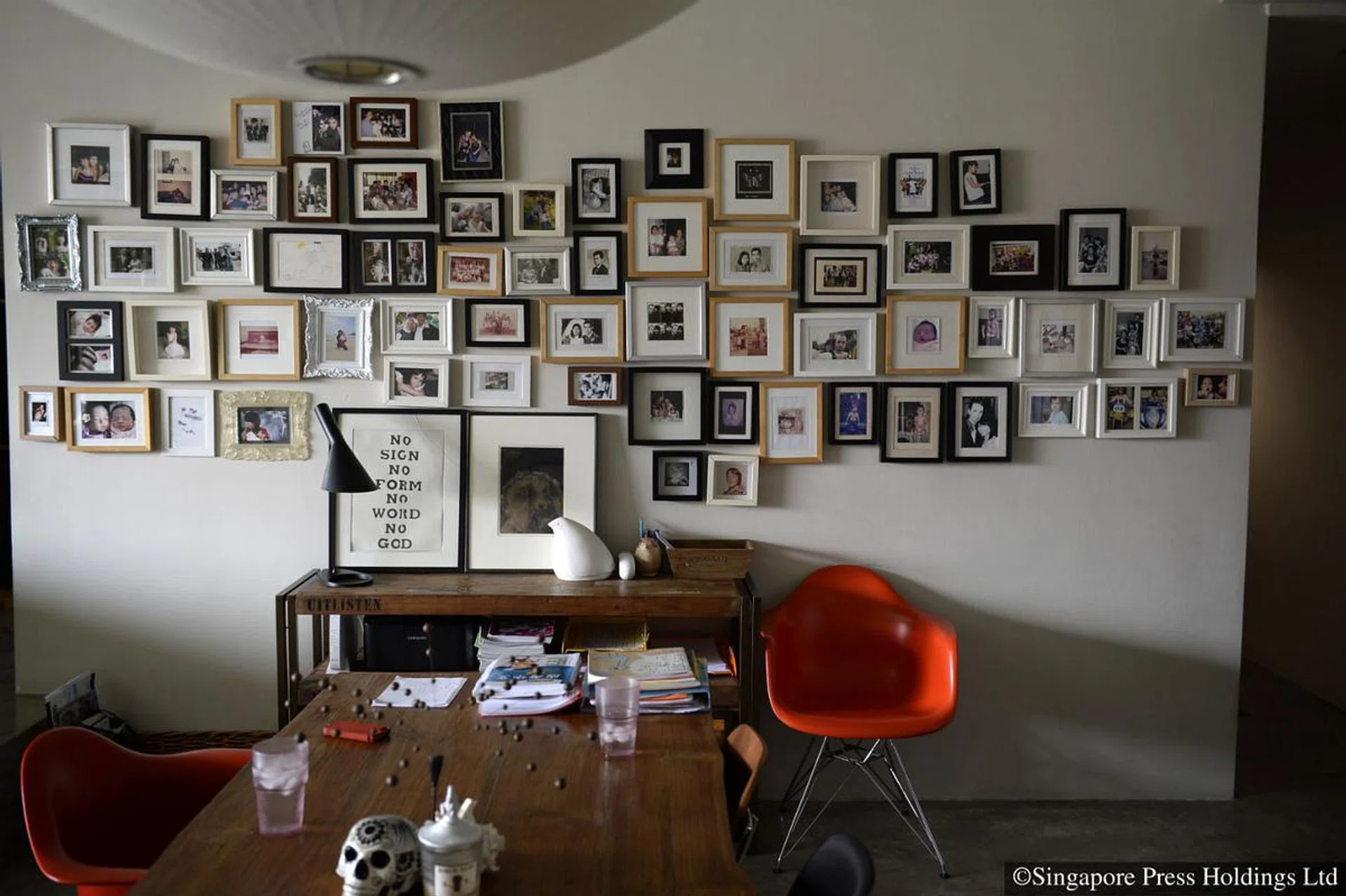 A wall of framed photographs in Ling Wu’s home along Toh Tuck Road.