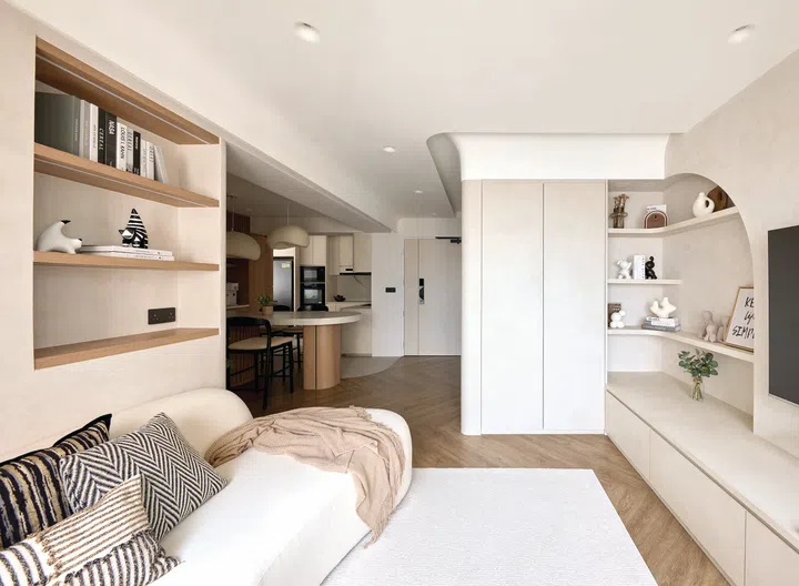 In the living area, a curved sofa echoes the gentle lines of the ceiling and walls.