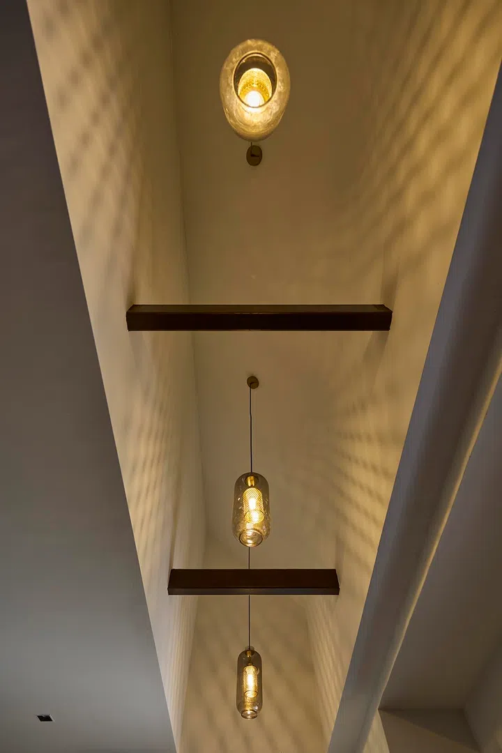 A discovered ceiling void is highlighted with accent lighting, casting patterned shadows that add depth and visual interest.