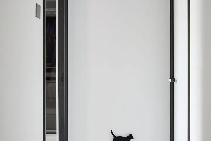 Monochrome corridor with a cat wall motif as an ode to the homeowner's black Persian-mix cat in a 5-room HDB in Edgedale Plains.