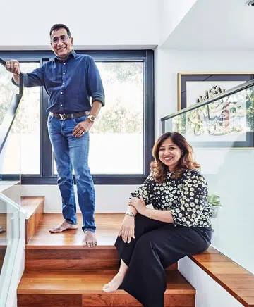 The Kareems, a couple in their 50s, photographed in 2021 at the stairwell landing in their 4-storey terrace house in Telok Kurau. Interior design by Hans Chua from Erstudio.