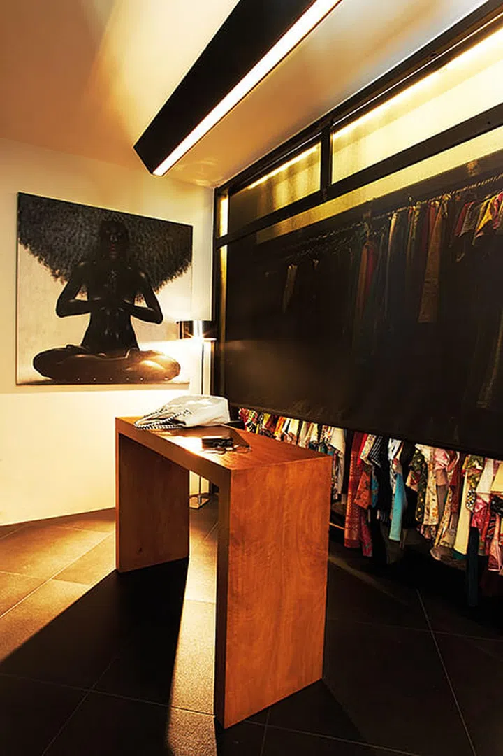The common bedroom adjoining the master bedroom was converted into a custom-made walk-in wardrobe, where designer, James, created an industrial look with cement screed flooring and metallic finish frames for the cupboards.