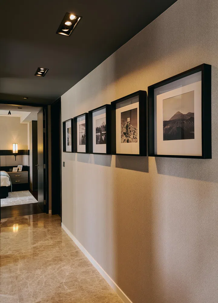 Black-and-white travel photographs personalise the corridor, extending the home’s narrative.