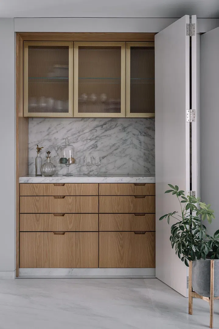 A home bar is concealed behind folding doors in this 2-bedroom apartment in Parsi, Mumbai.