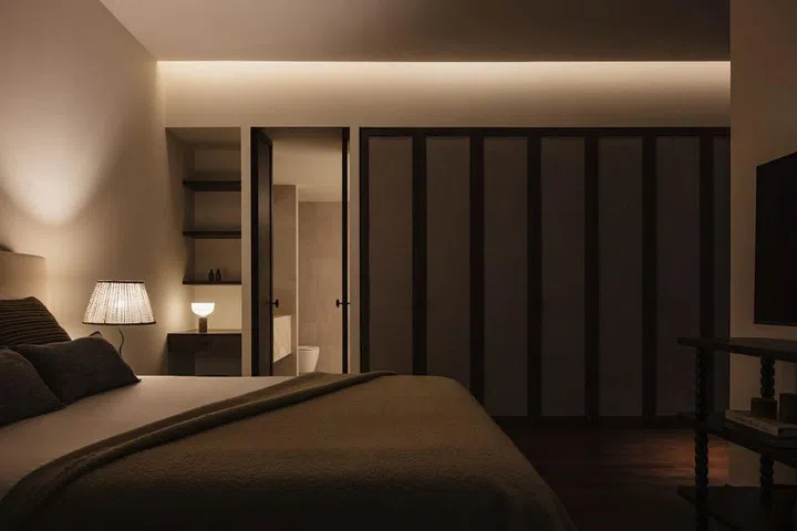 Lim created new wardrobes in the master bedroom with dark wood frames and panels upholstered with grey fabric. (Photo: Studio Periphery)