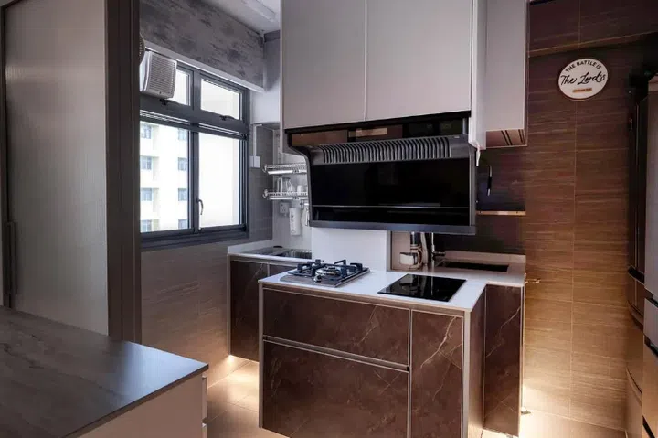 The kitchen was designed around a pillar enclosing a sewerage pipe that also blocks light from the window. To maximise natural light, the hob and hood were installed in front of the pillar.