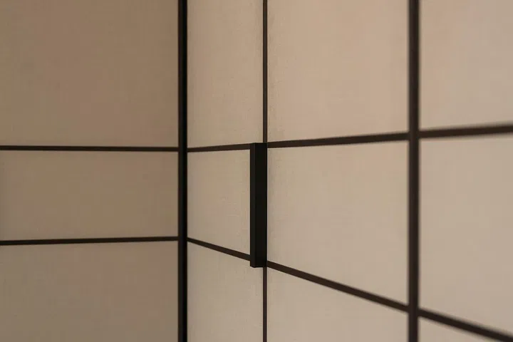 Custom recessed pulls are concealed within the wardrobe framing, remaining almost invisible from the front to preserve the clean, minimalist façade.