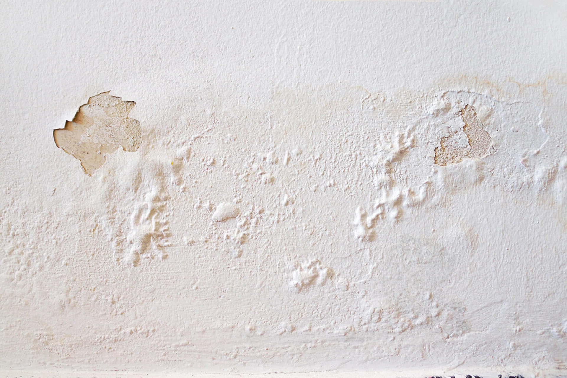 Rain water leaks on the wall causing damage and peeling paint.