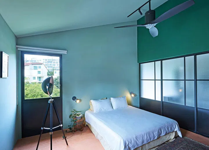 The green walls and reddish microcement floor in the guest room offer guests
a playful, yet restful space.