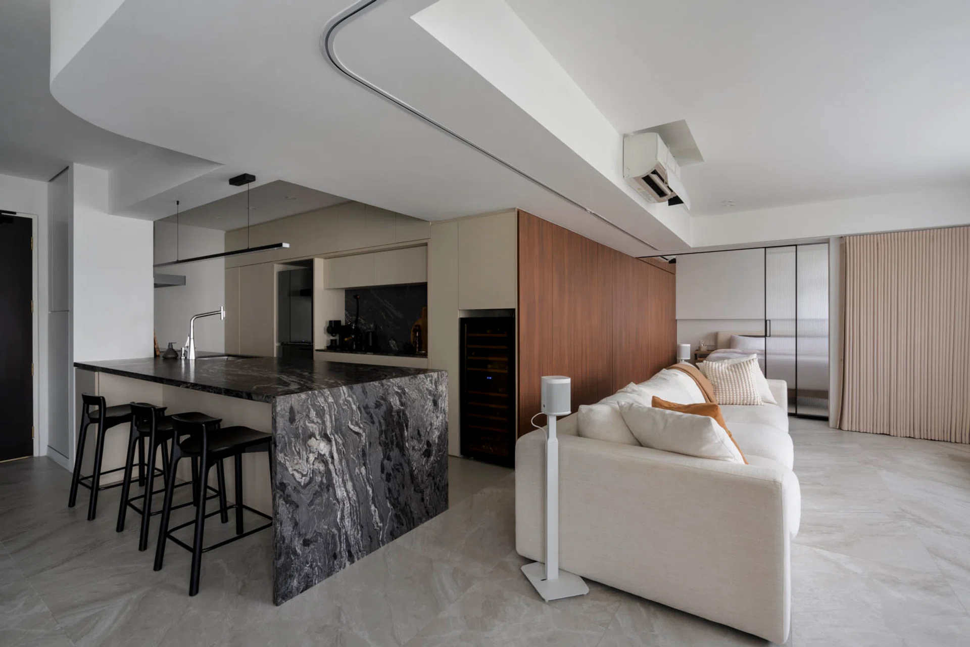 Wood cladding hides bathroom doors and wardrobes, keeping the living area calm and uncluttered.