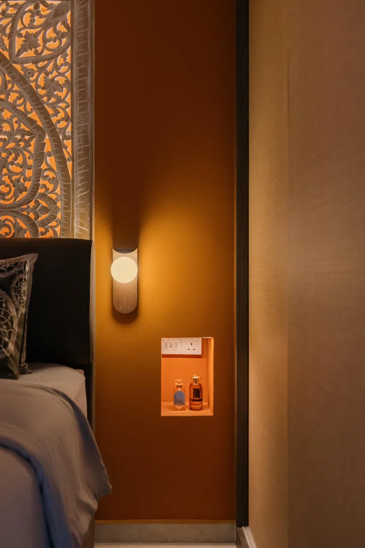 Built-in niches beside the bed keep everyday essentials within reach while maintaining the room’s clean, uncluttered look.