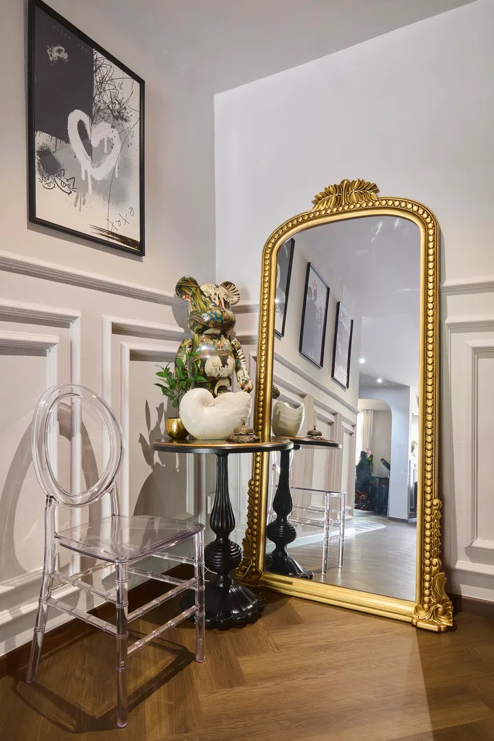 The homeowners with their two children in the living area, where wainscoting and arched openings introduce the home’s layered mix of classical detail and everyday family life.