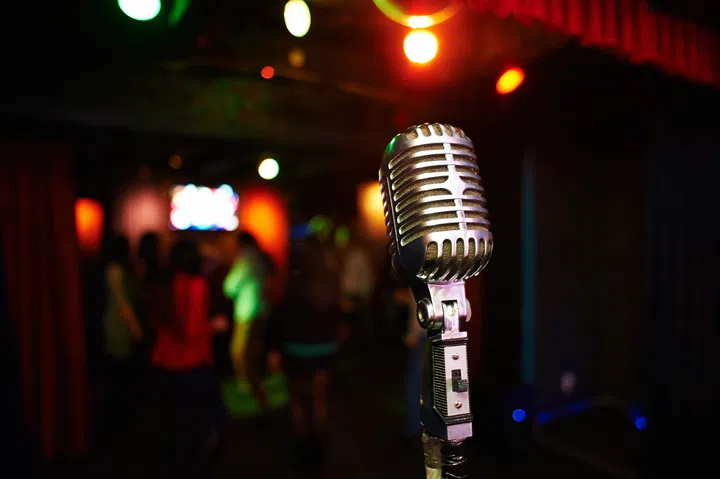 Stylish retro microphone on a background of dancing people.