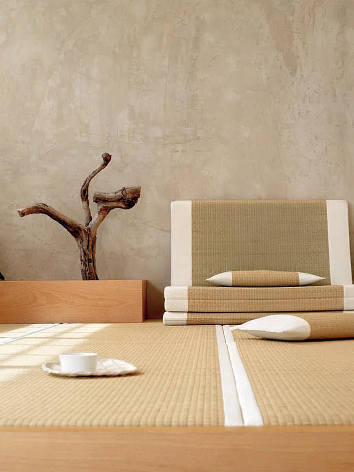 The meditation room is a harmonious blend of nature and Japanese-inspired elements, as seen in the tatami mats and plain cement screed wall.