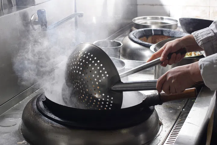 Close up of working chef preparing chinese food, Food frying in wok pan. 