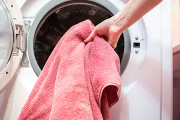 open door of the washing machine with dirty laundry