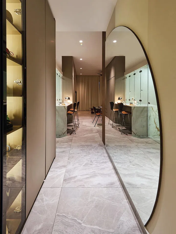 Nigel and
Shairah both
grew up in
five-room flats
and it is really
important to
them that their
new home has
open living and
dining spaces.
A large curved
mirror panel
helps to open
up the narrow
walkway space.