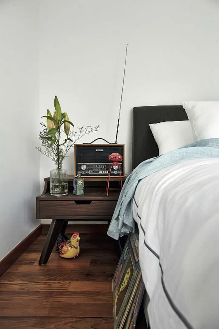 Located on the mezzanine, the master bedroom is furnished with just the essentials - a bed with an upholstered headboard and wooden nightstands from Commune.