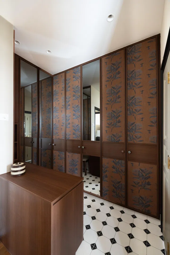 Most of the interior designer’s efforts went into creating a gorgeous “walk-in” closet area, sectioned off by a dark wood drawer. 