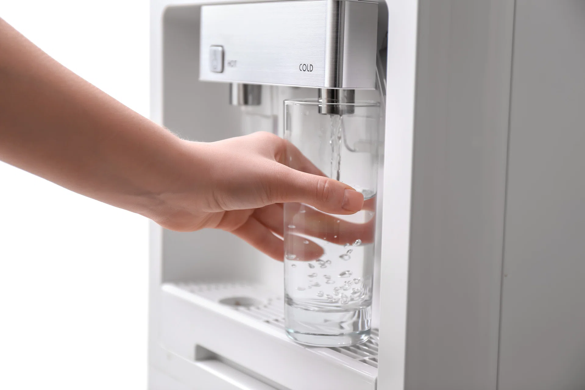 Woman filling glass with water from cooler, closeup.