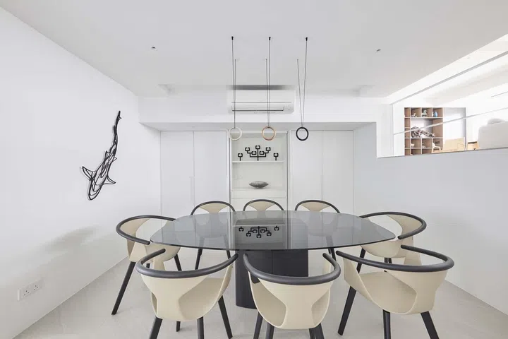 A black and cream dining table set juxtaposed against an all white kitchen in this 3,500 sq ft 4-bedroom Pandan Valley condo.