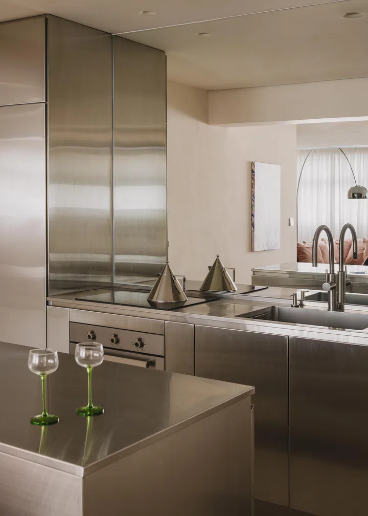 Decked out completely with hairline stainless steel, the finishings and appliances match in Brandon and Jolene’s kitchen, including the iconic triangular Alessi Il Conico kettle designed by Aldo Rossi. The world-renowned kettle series, pioneered by the legendary Alessandro Mendini in the early 80s. The collection remains one of Alessi’s best-sellers. 