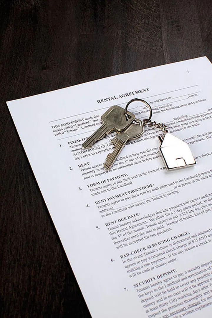 A set of keys placed on a rental agreement document.