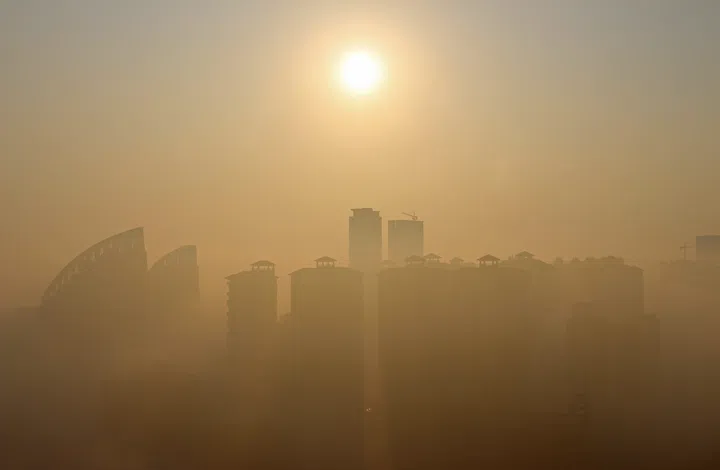Landscape view of a city in China during sunrise covered in fog.