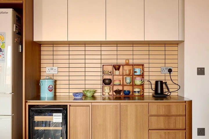 Warm timber cabinetry and buttery subway tiles continue the home’s cosy palette in the dry kitchen.