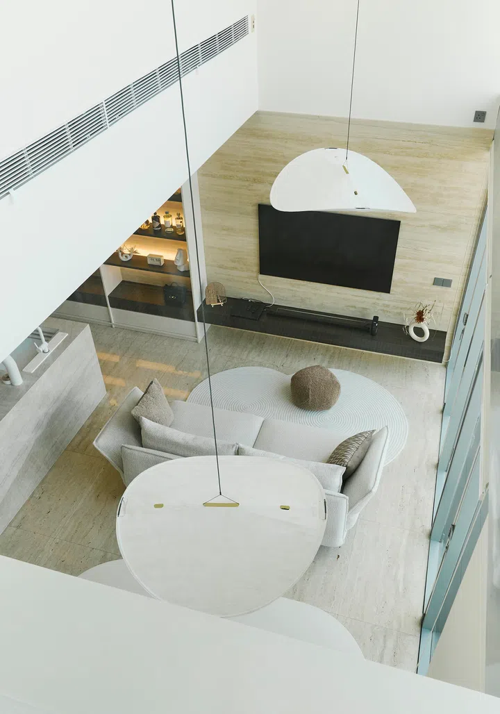 From the mezzanine-level master suite, the living area below unfolds like a cinematic scene — a nod to the couple’s love for film and architectural drama.