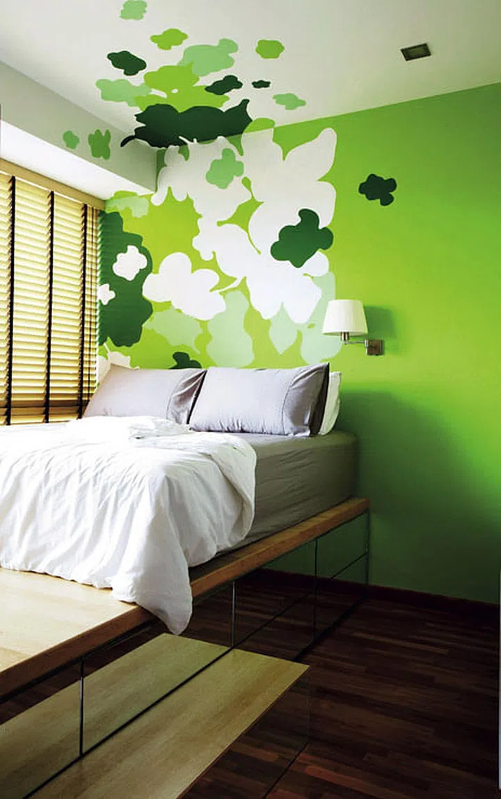 The graphic flower petals in shades of green in the bedroom are painted on the feature wall to perk up the compact space