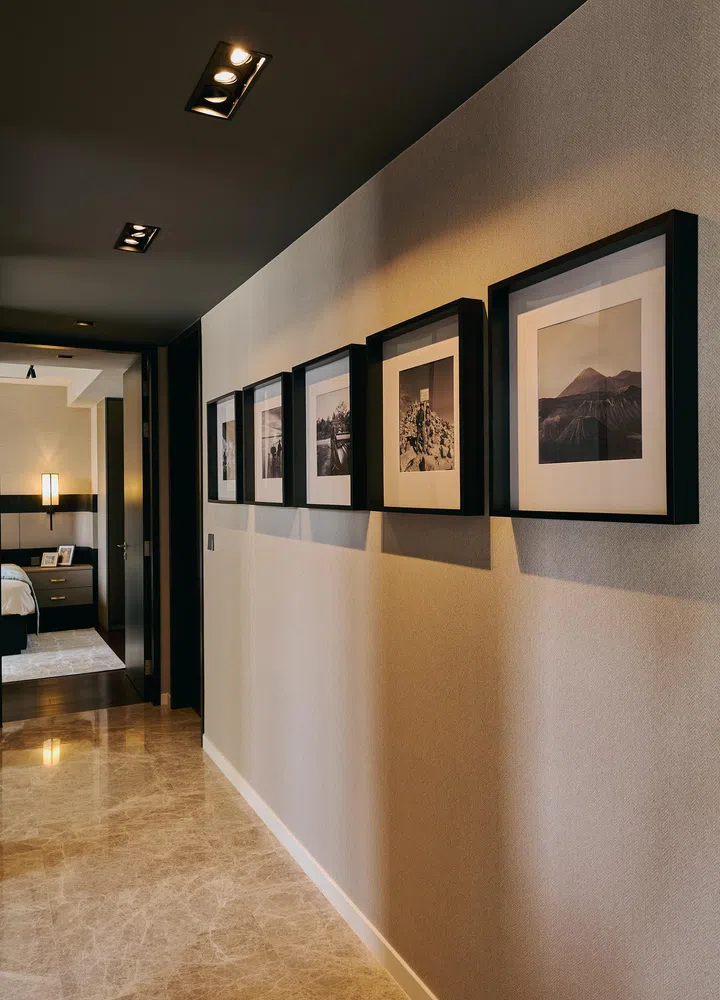 Black-and-white travel photographs personalise the corridor, extending the home’s narrative.