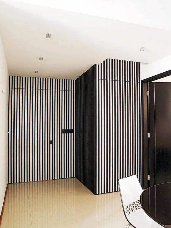 Striped feature wall in a 800 sq ft black and white-themed 2-bedroom condo.