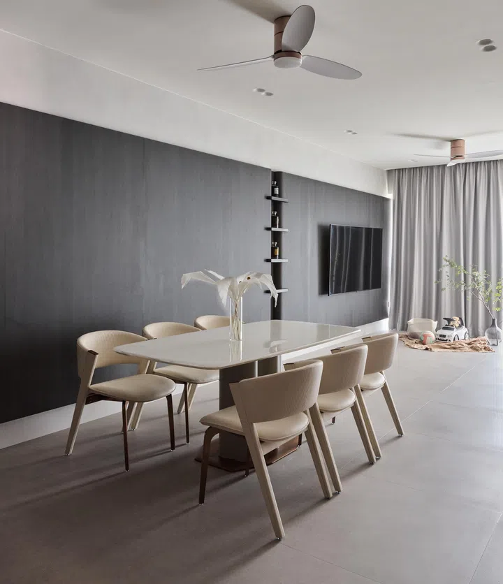 The dining area with a marble dining table and chairs, complemented by a dark wood feature wall and a whisky display shelf, creating an inviting atmosphere for family meals.