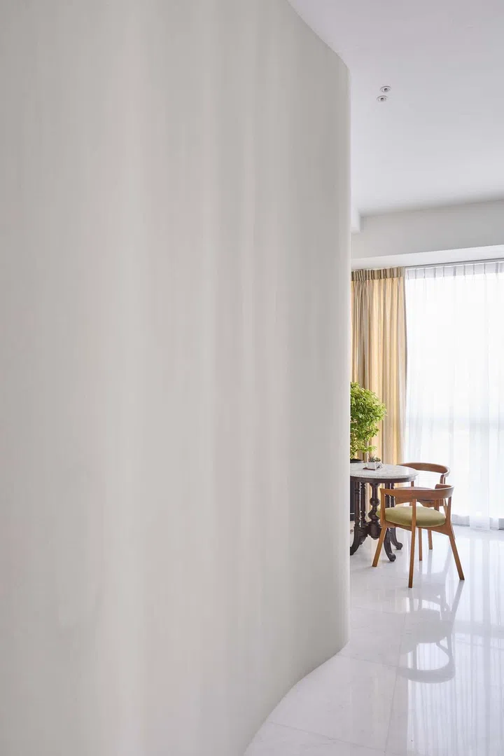 A curved wall leading into the dining area in a 1,550 sq ft 3-bedroom condominium apartment in Keppel Bay. Interior design by Weiken.