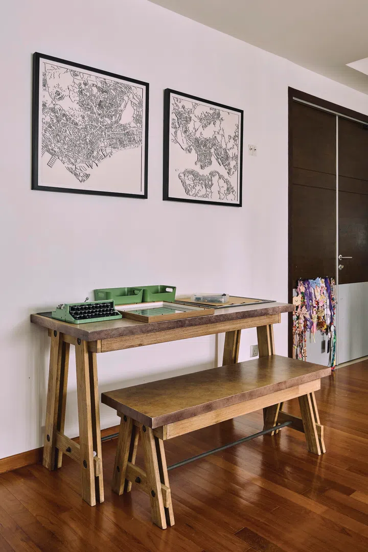 Two aerial maps of Singapore and Hong Kong hang on the wall of the family area.