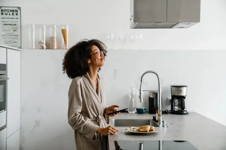 Image of a beautiful young african woman indoors in the kitchen. Photo 123RF