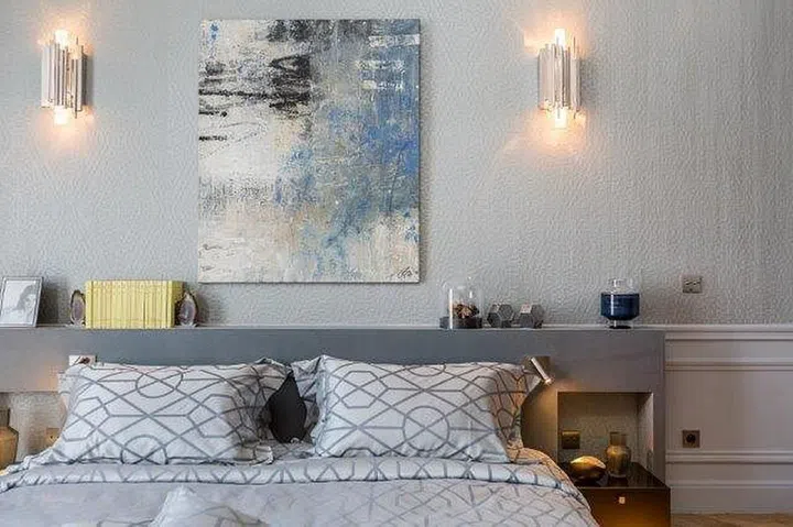 Customised nightstands by the designer and a curated selection of paintings and decor pieces come together to create a stylish and restful ambience in the second bedroom. Colours chosen reflect the shades of the sky.