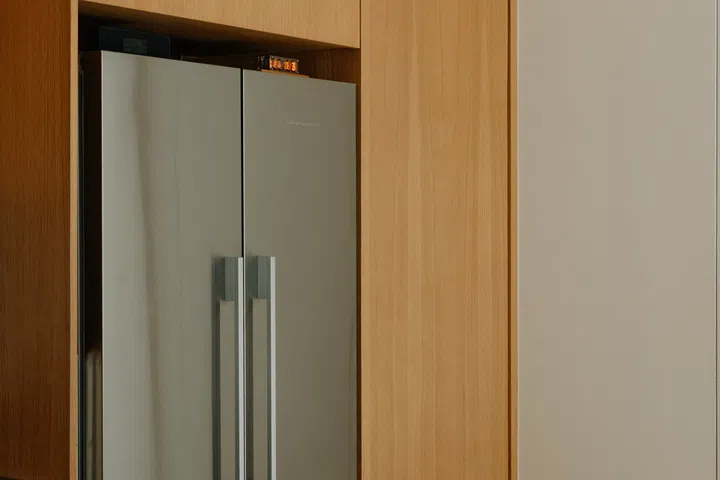 Recessed detailing replaces conventional handles, lending the bespoke oak cabinetry a refined, architectural appearance.