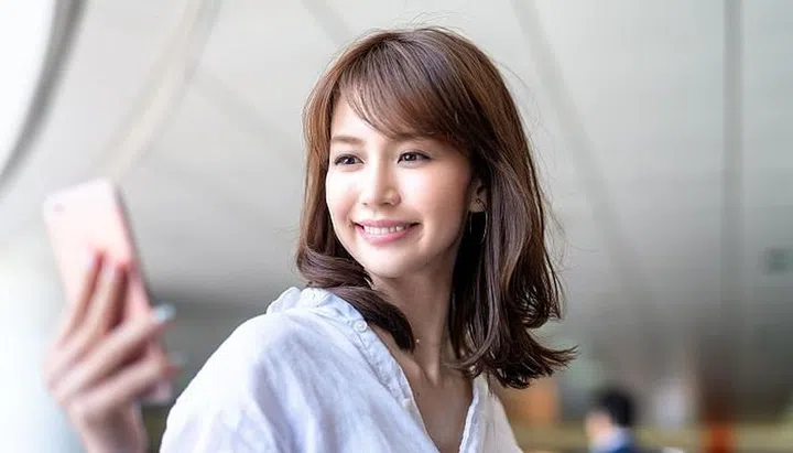 Beautiful japanese woman looking at smartphone inside subway station.