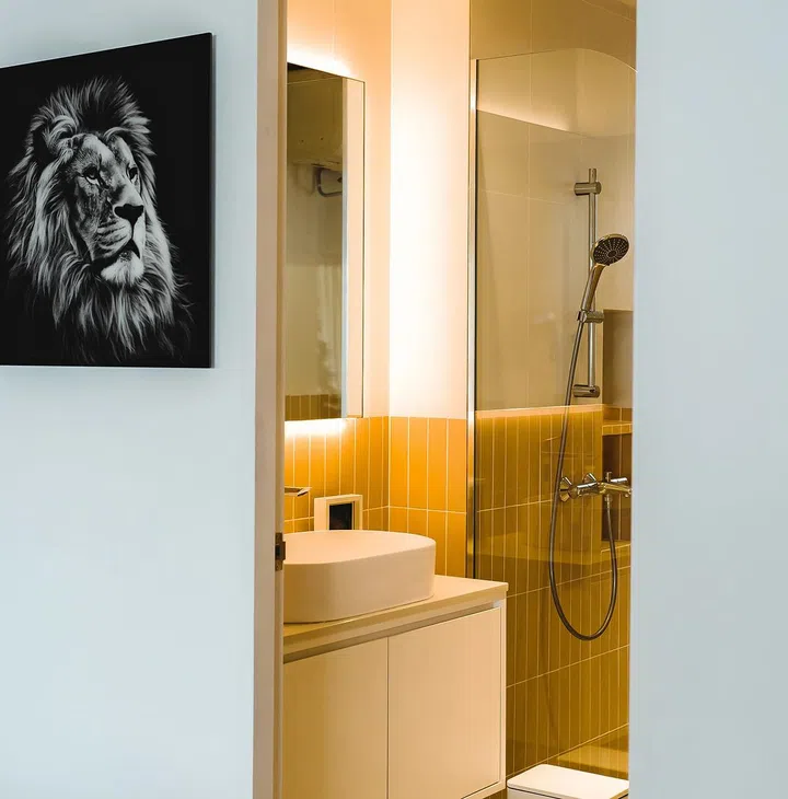 Mustard-
coloured wall

tiles elevate
the feel of
the common
bathroom,
which was also
extended.