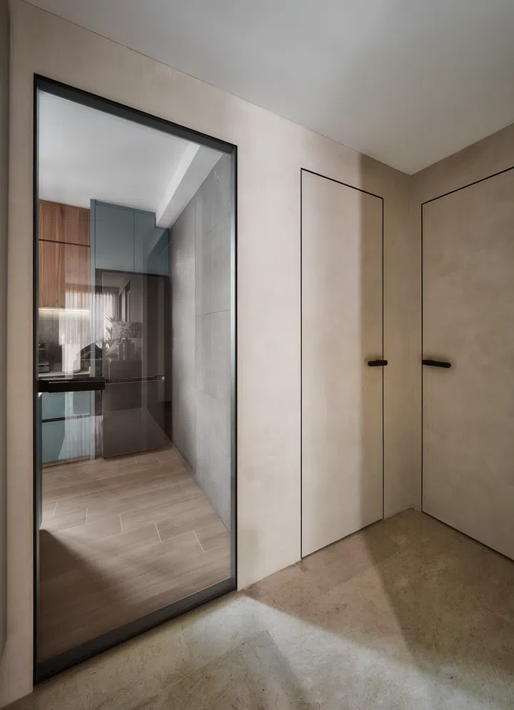 Concealed storage blends into wallpapered panels, while a checkered glass sliding door leads to the kitchen — keeping spaces bright yet private.